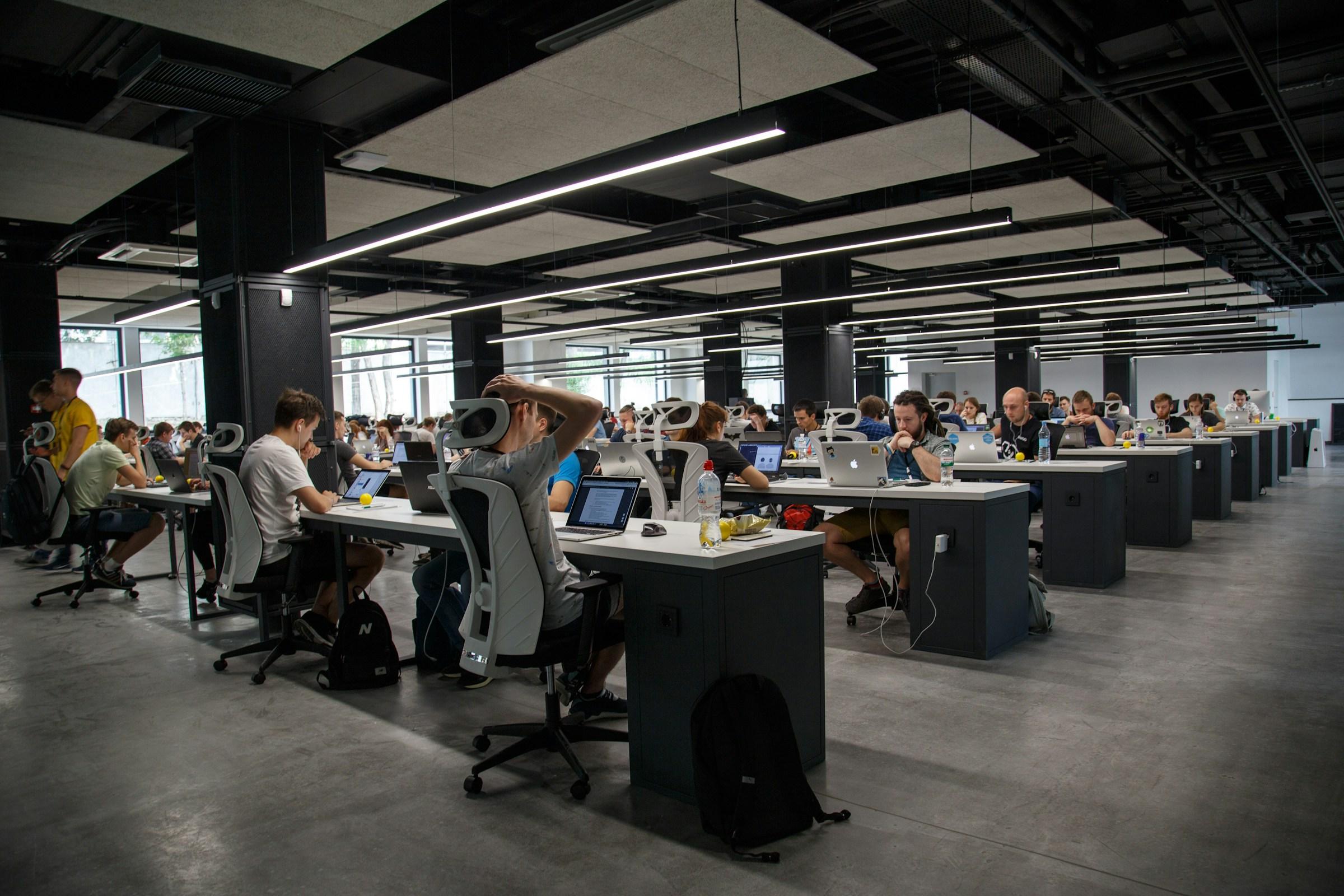 A large team of professionals working at desks in an open-plan office